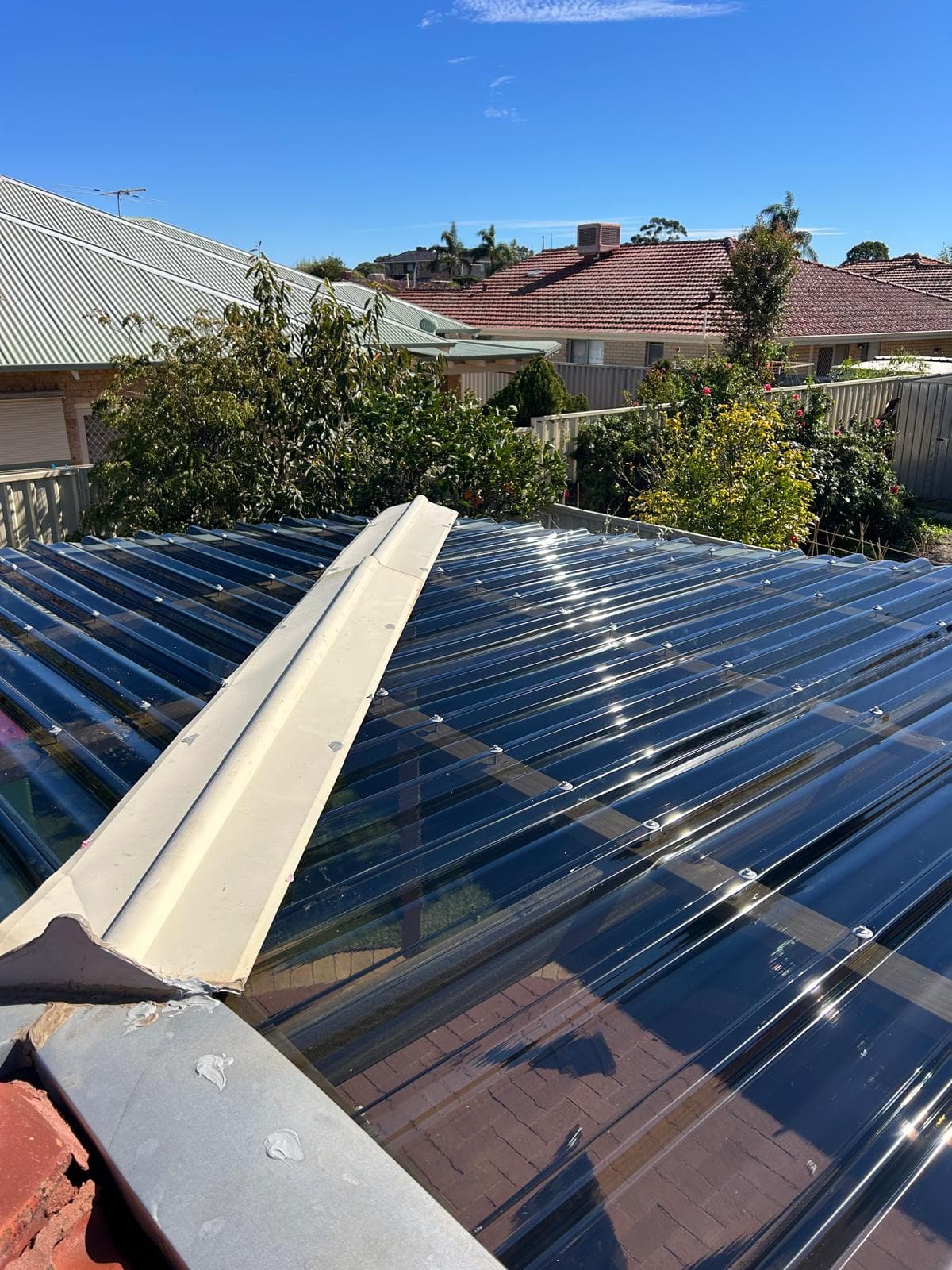 Ridge capping fitted along the peak of newly laid clear roof sheeting