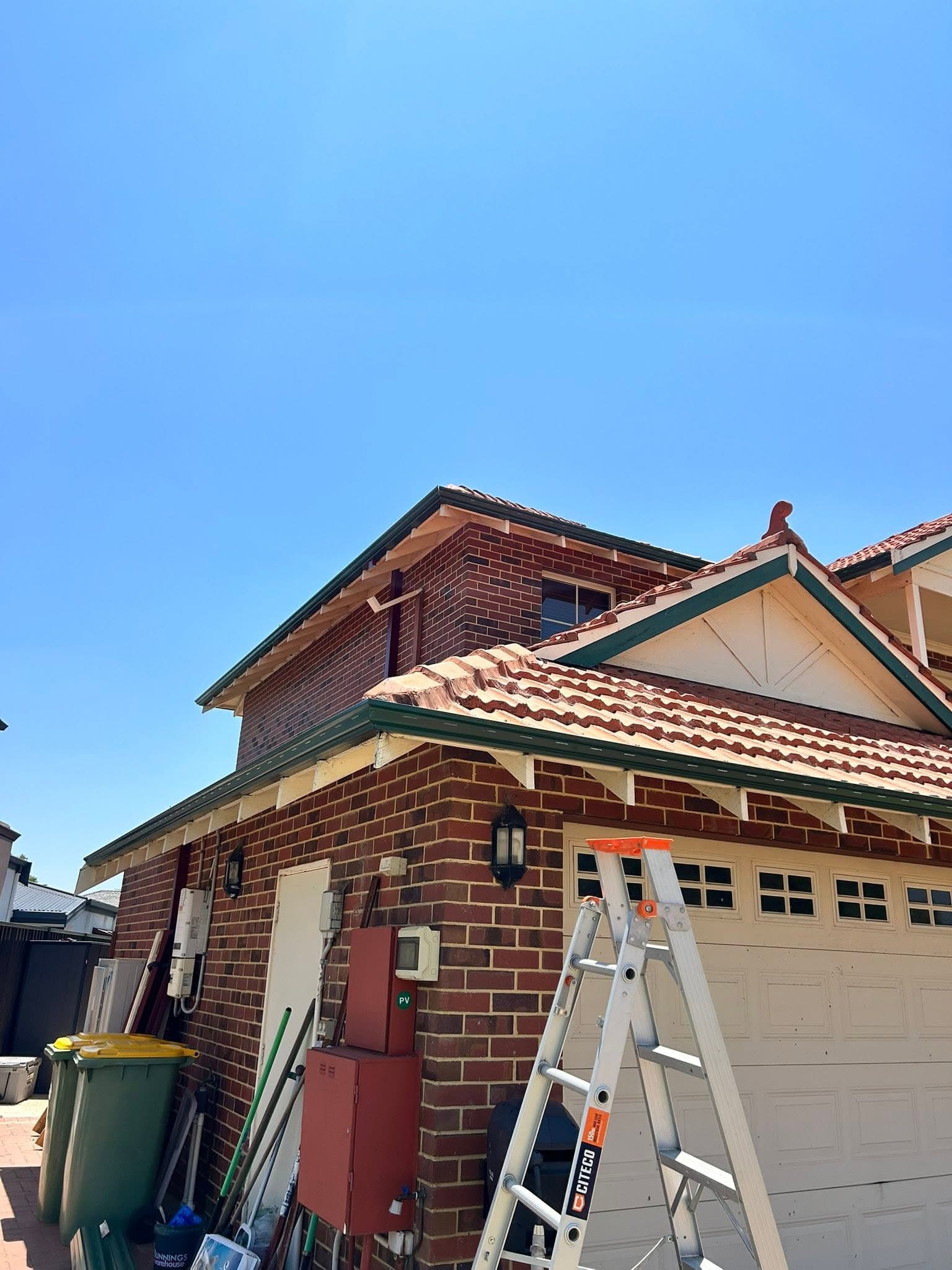 Two-storey home with a terracotta tiled roof and fresh green fascia